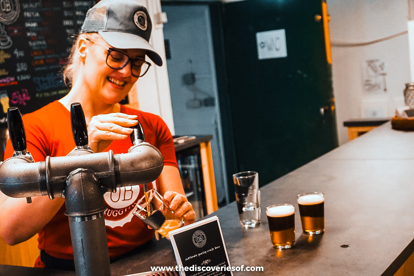 Host pouring tasting glasses of beer from the taps at the Ölvisholt Brugghús bar in Iceland
