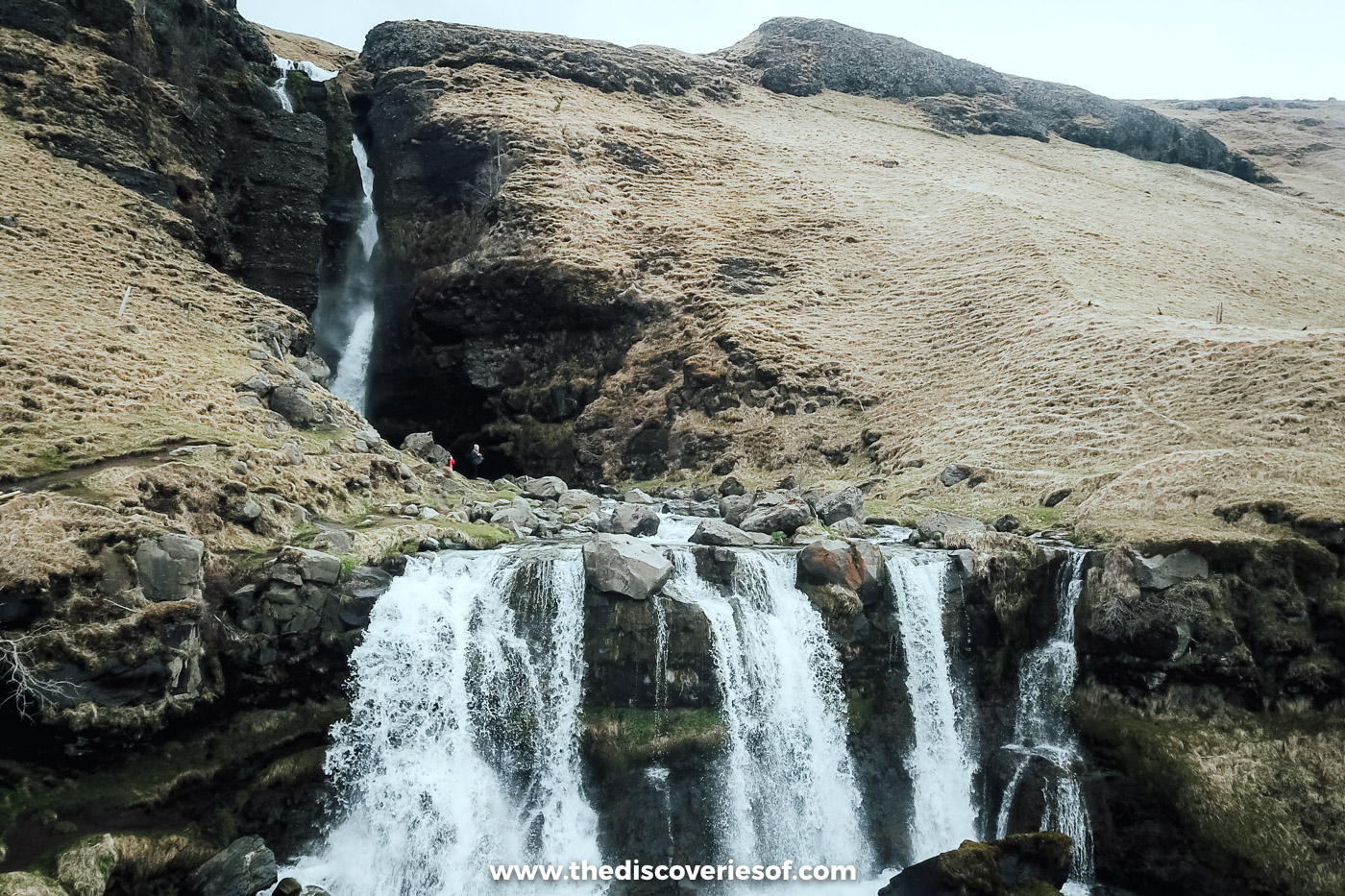 Gluggafoss in the FljótshlÃð valley, its upper fall dropping into a wide lower cascade below brown slopes