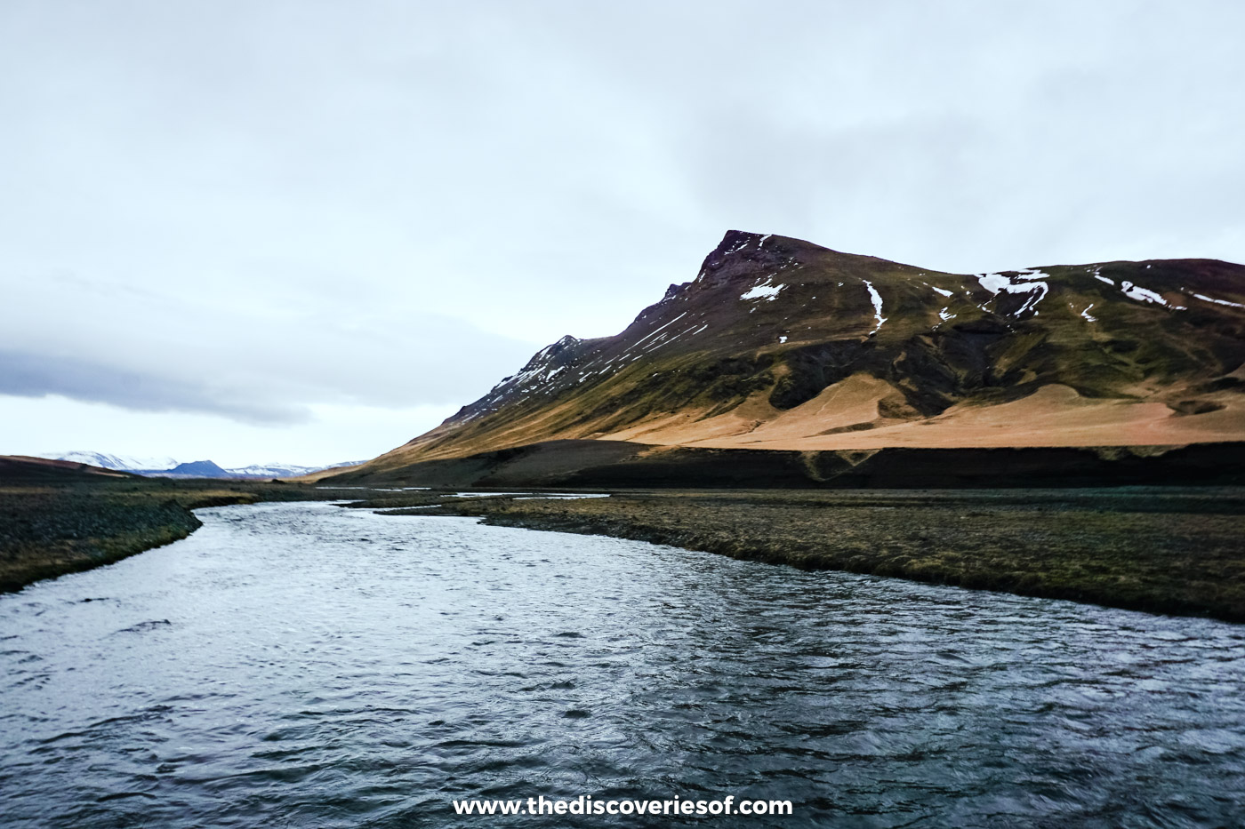 A braided river and black gravel below a snow-streaked peak on the plains near Hekla in south Iceland
