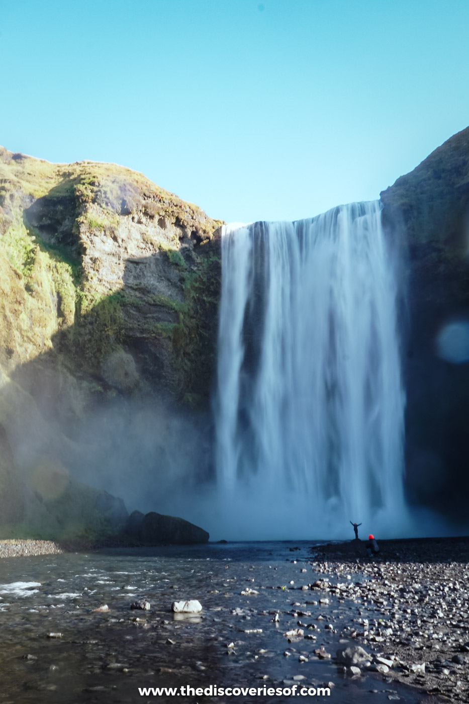 Skógafoss thundering over its cliff in bright September sunshine, with spray rising from the plunge pool, south Iceland