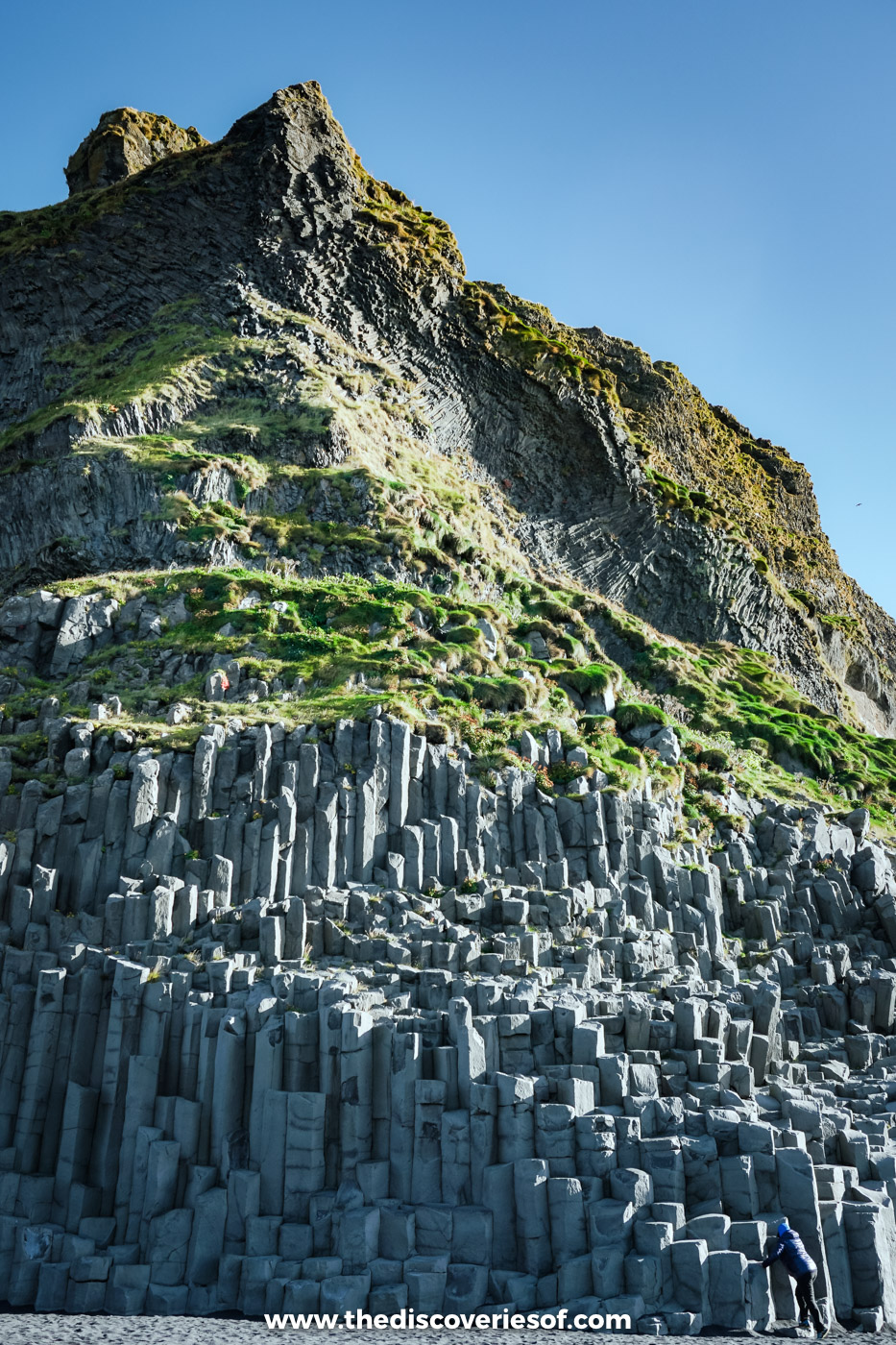 Tall hexagonal basalt columns stacked up the cliff face at Reynisfjara black sand beach near VÃk, south Iceland