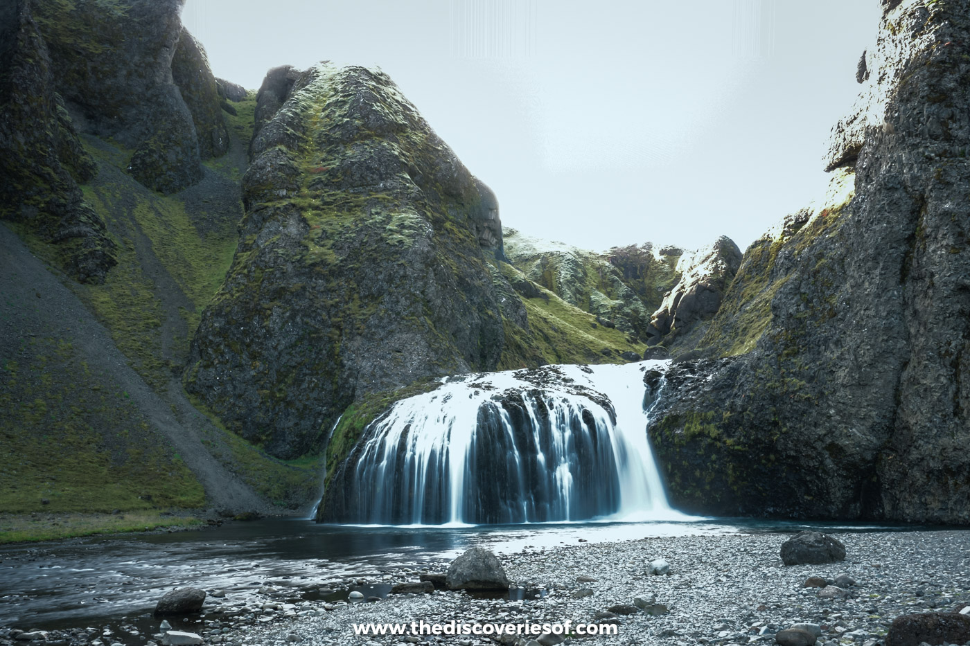 Stjórnarfoss dropping in two steps into a clear pool surrounded by mossy rock near Kirkjubæjarklaustur