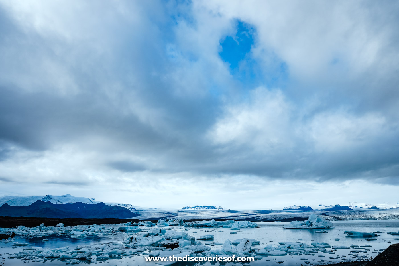 Heavy rain clouds over the icebergs and dark mountains of Jökulsárlón glacier lagoon in September