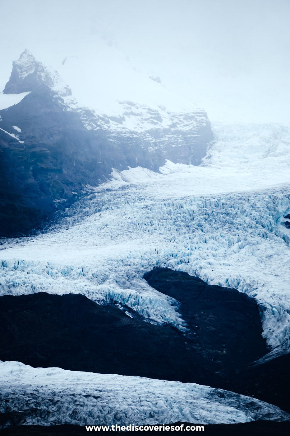 The crevassed blue-white tongue of Fjallsjökull glacier descending towards Fjallsárlón lagoon