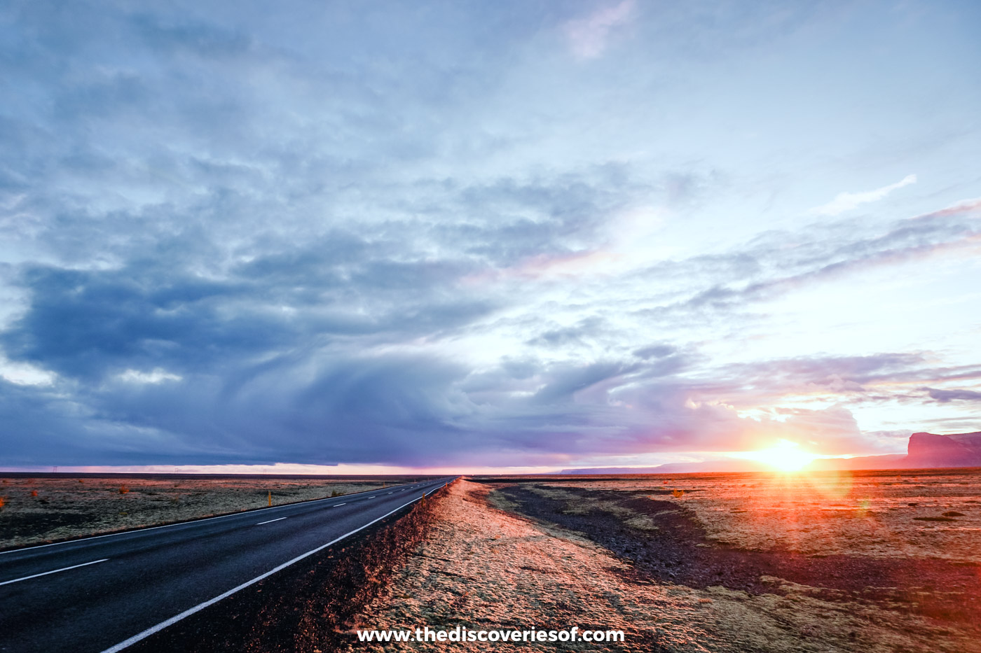 The Ring Road stretching across flat sandur plains towards a low sun at sunset in South Iceland