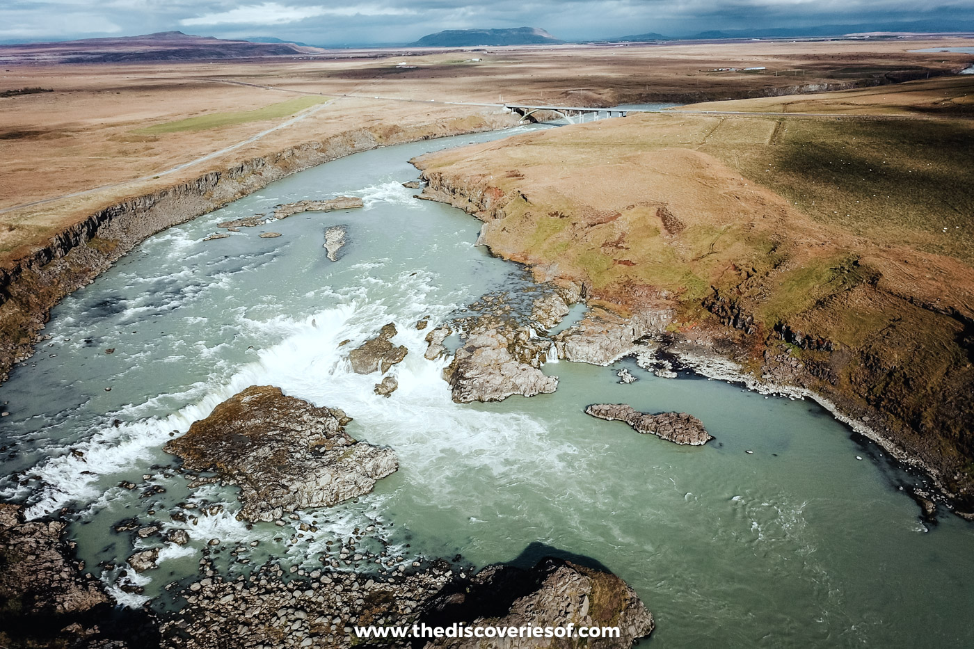 Aerial view of Urriðafoss, white water curving across the Þjórsá between low cliffs and brown moorland