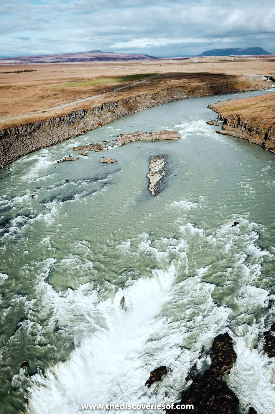Drone view looking down on Urriðafoss as the Þjórsá river churns white over a wide lava ledge, south Iceland