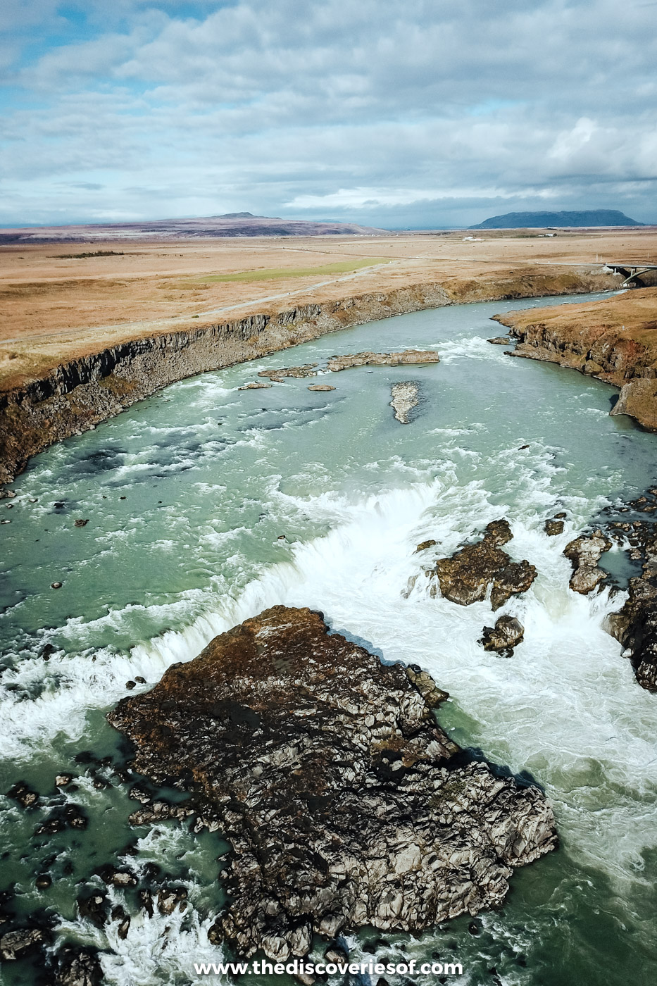 Aerial view of Urriðafoss waterfall where the wide Þjórsá river pours over a low rocky ledge
