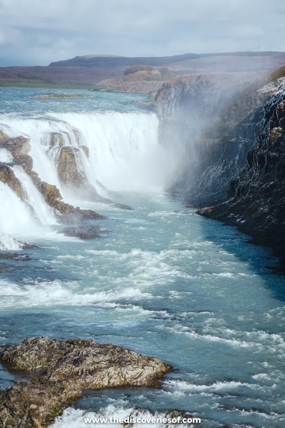 Gullfoss pouring into the narrow HvÃtá canyon in sunshine, with spray rising from the lower fall
