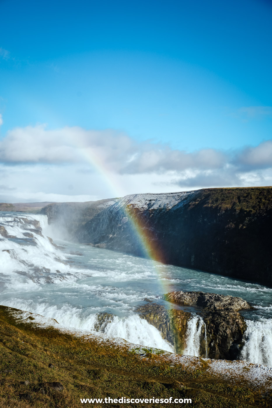 A rainbow forming in the spray over the lower fall of Gullfoss, with the canyon wall beyond