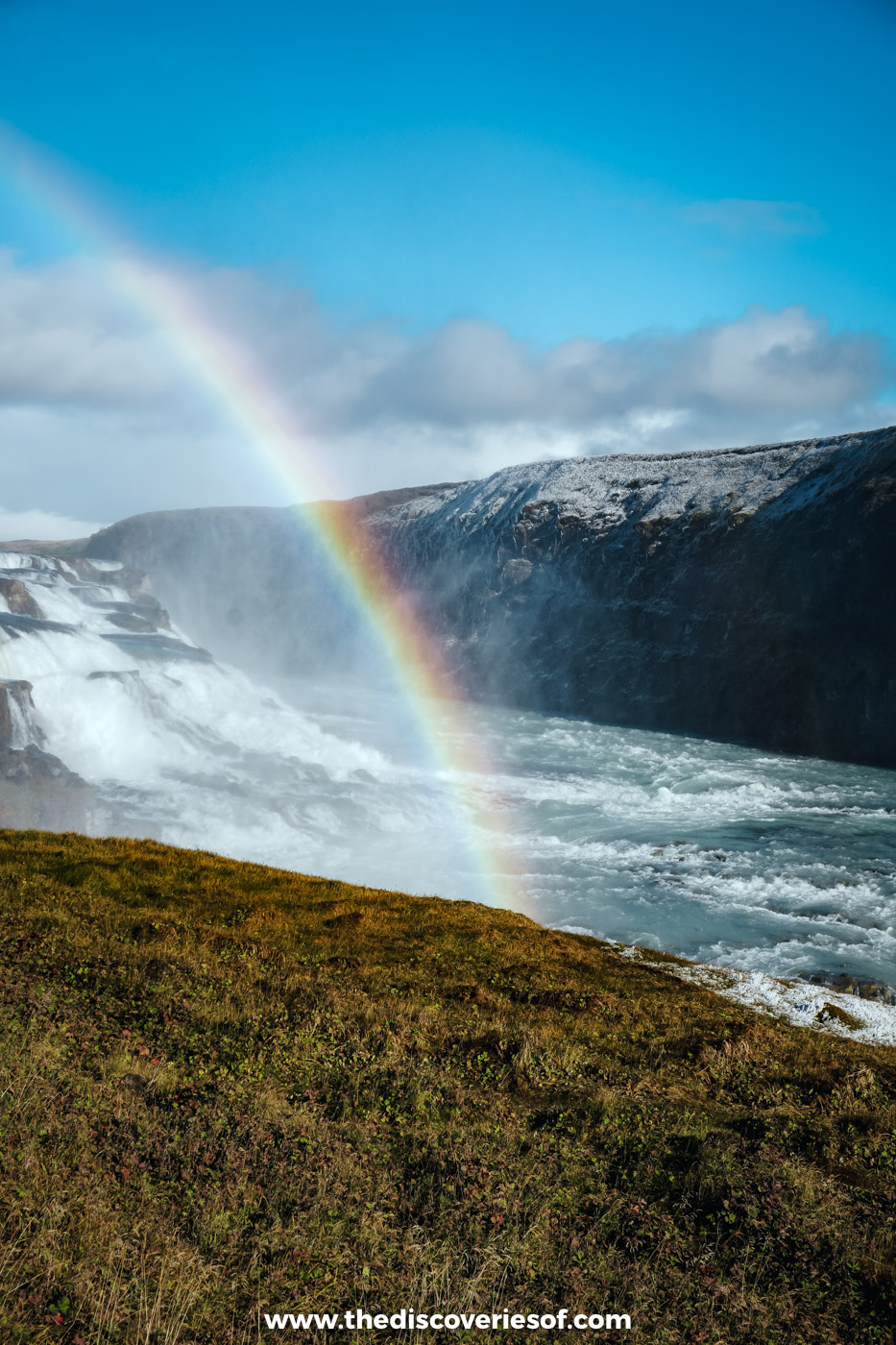 A rainbow arching across the spray above Gullfoss and the Hvítá canyon under a deep blue September sky