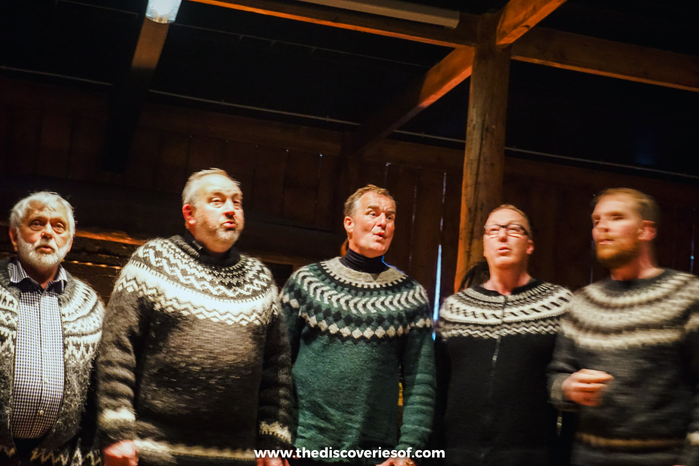 Male choir in traditional Icelandic lopapeysa sweaters singing at a Viking feast in Hvolsvöllur
