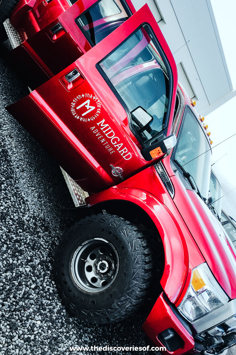 Close-up of the red Midgard Adventure super jeep's oversized wheel and door in Hvolsvöllur, South Iceland