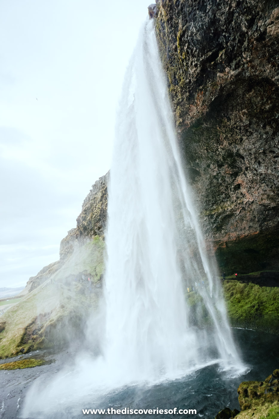Seljalandsfoss seen from the side, with the path running towards the hollow behind the falling water, south Iceland