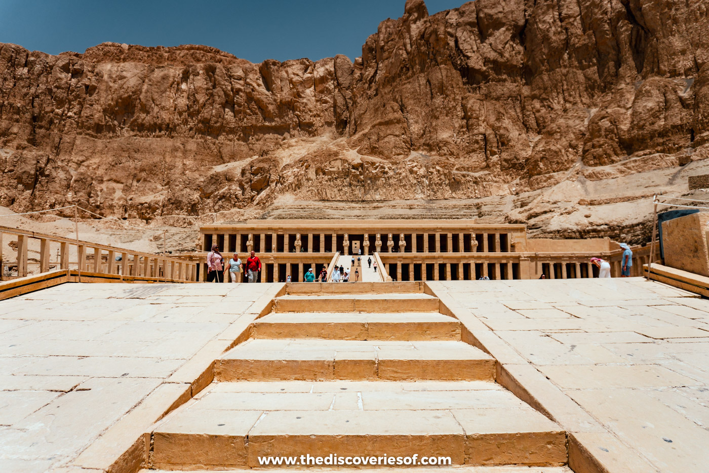 Wide stone ramp rising to the colonnades of the Mortuary Temple of Hatshepsut beneath the cliffs of Deir el-Bahari