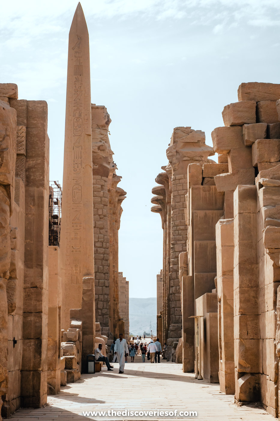 Granite obelisk rising between ruined walls and pylons at Karnak Temple in Luxor