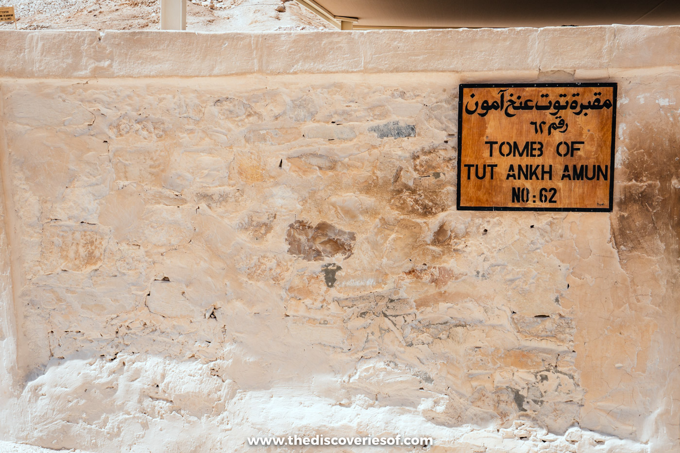 Wooden sign reading Tomb of Tut Ankh Amun No 62 on a stone wall in the Valley of the Kings