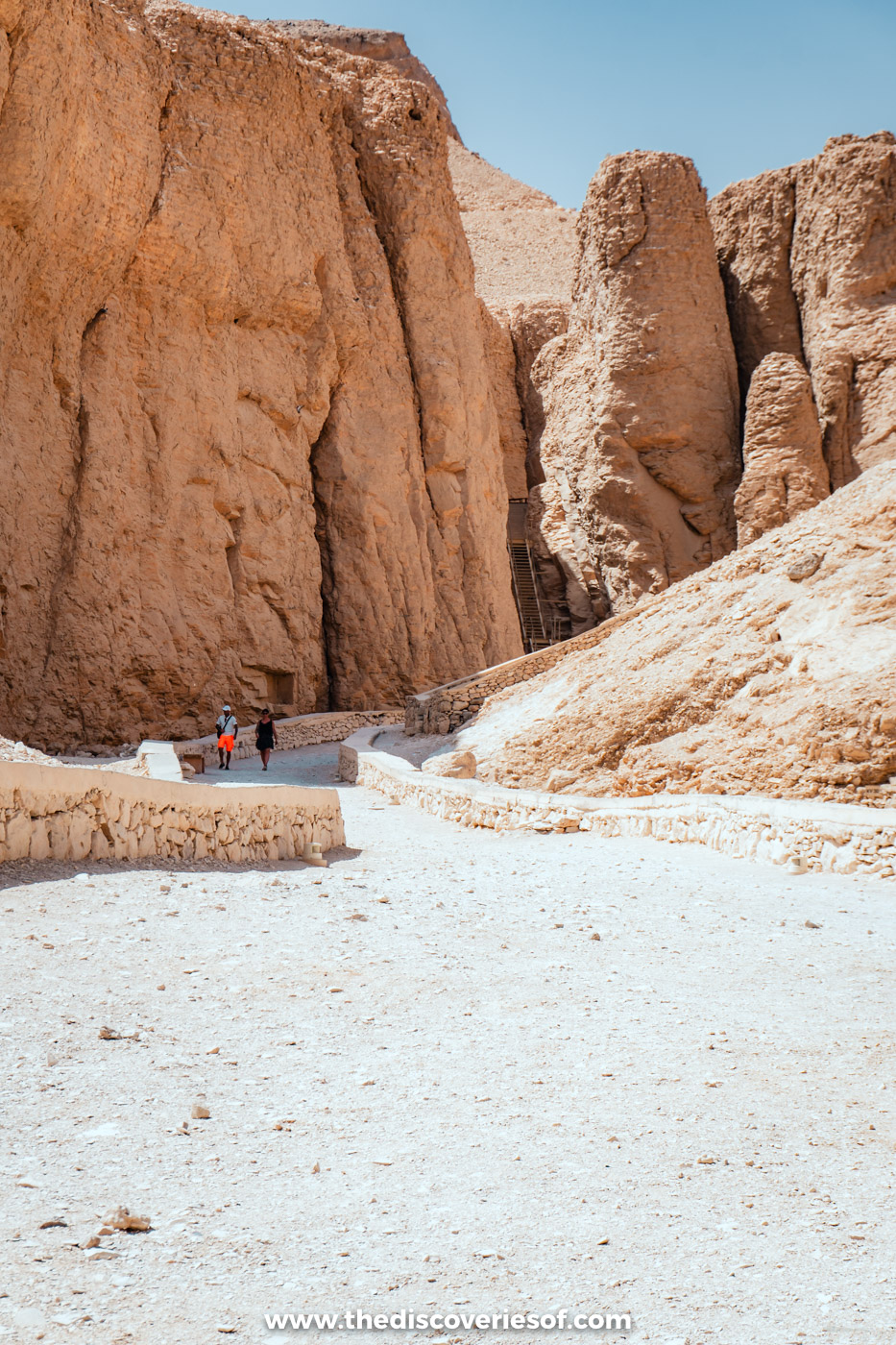 Tall eroded limestone cliffs and a gravel path at the head of the Valley of the Kings in Luxor