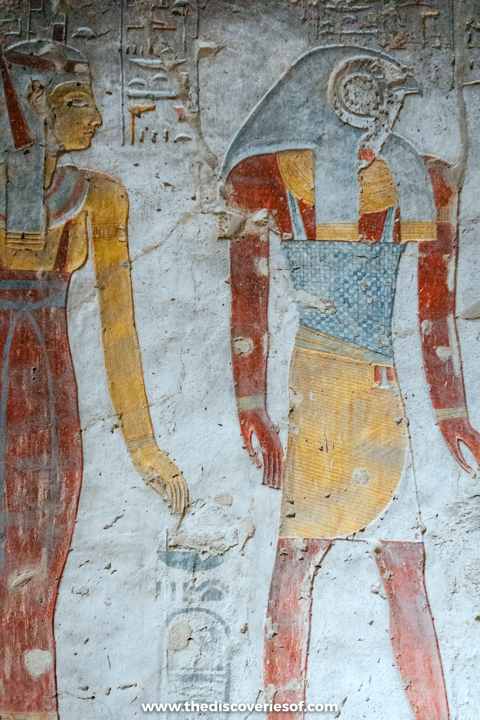 Painted relief of the falcon-headed god Ra-Horakhty facing a yellow-skinned figure of Tausert, tomb KV14