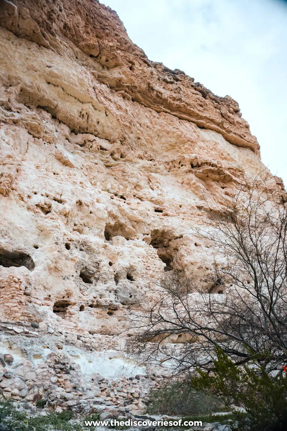 Limestone cliff face with stone wall remains at its base along the trail at Montezuma Castle