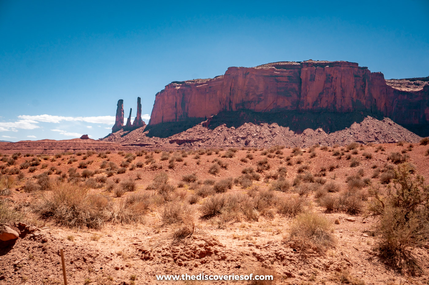 Mitchell Mesa and the Three Sisters spires across the desert in Monument Valley