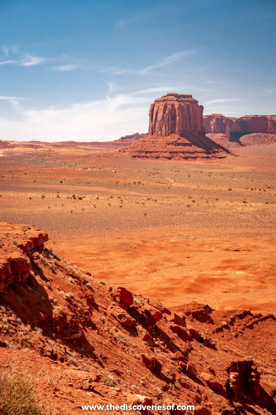 View across the red valley floor to a distant butte from John Ford's Point in Monument Valley
