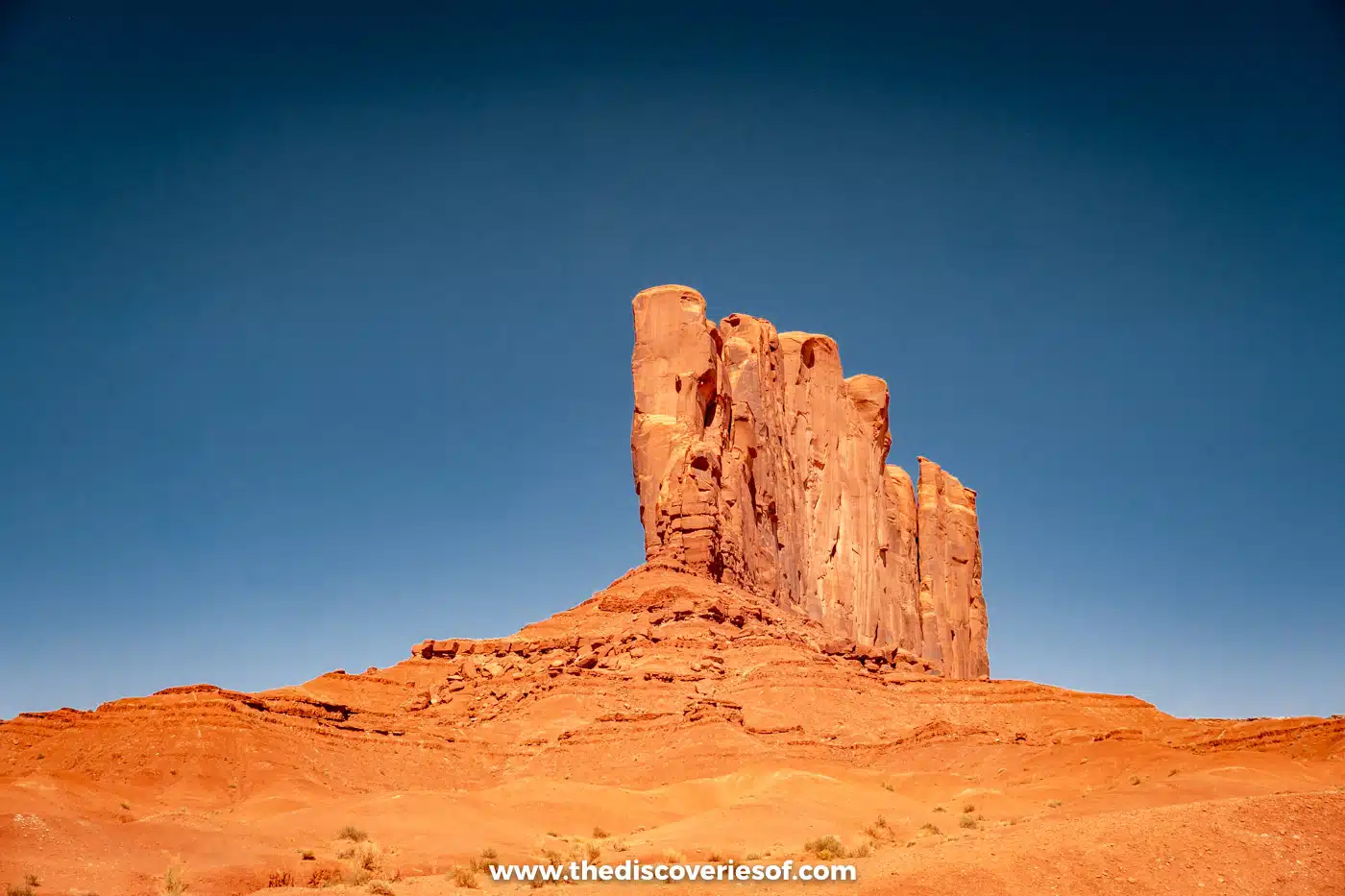 Camel Butte standing above orange sand at viewpoint 5 on the Monument Valley Valley Drive