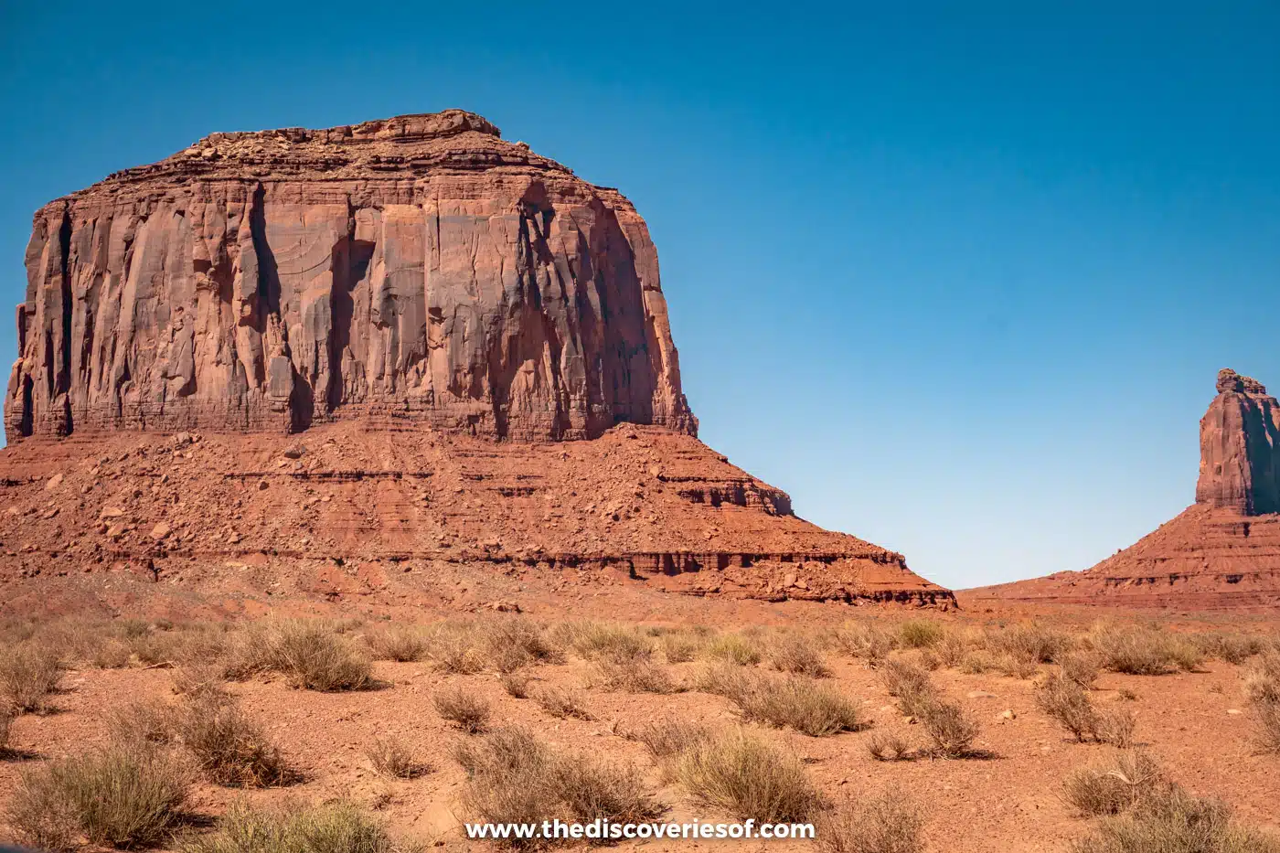 Merrick Butte towering over desert scrub on the Valley Drive in Monument Valley
