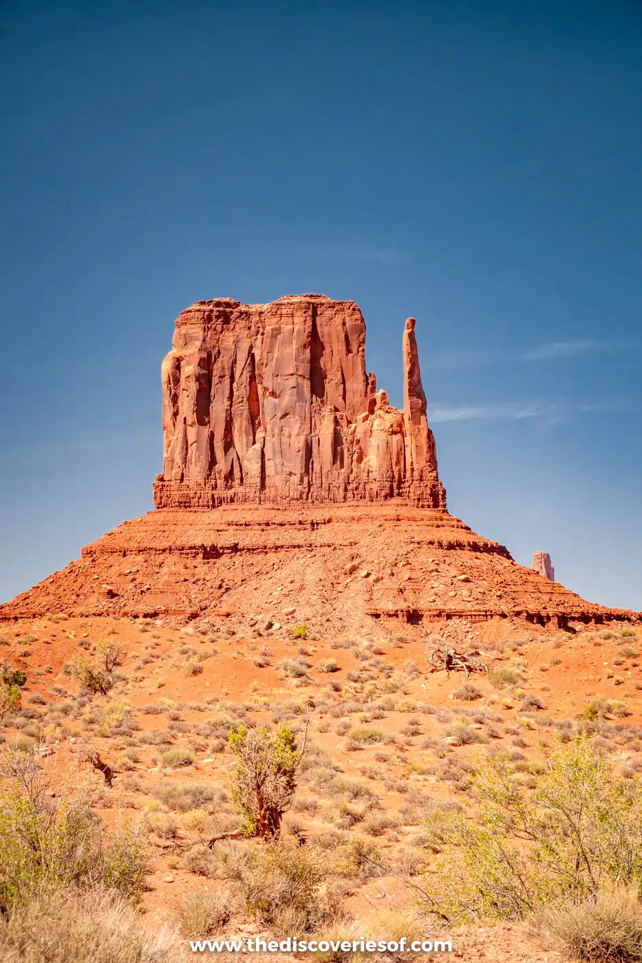 West Mitten Butte rising above desert scrub on the floor of Monument Valley