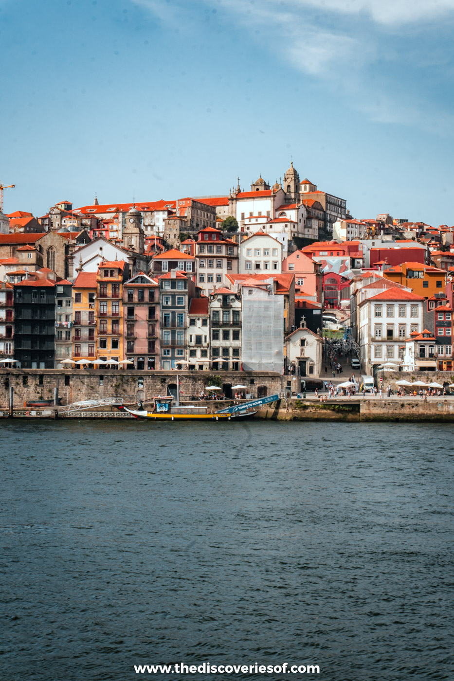 Tall, colourful houses of Porto's Ribeira district stacked above the Douro river on a sunny day