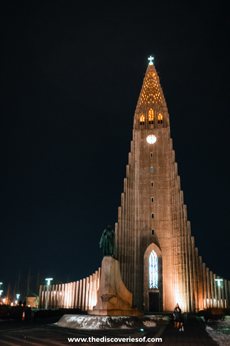 Hallgrímskirkja's stepped concrete tower floodlit against a black December night sky in Reykjavik