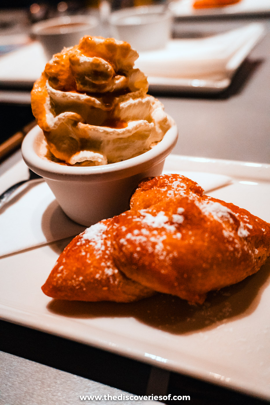 Golden fried pastries served with a pot of whipped cream on a December evening in Reykjavik