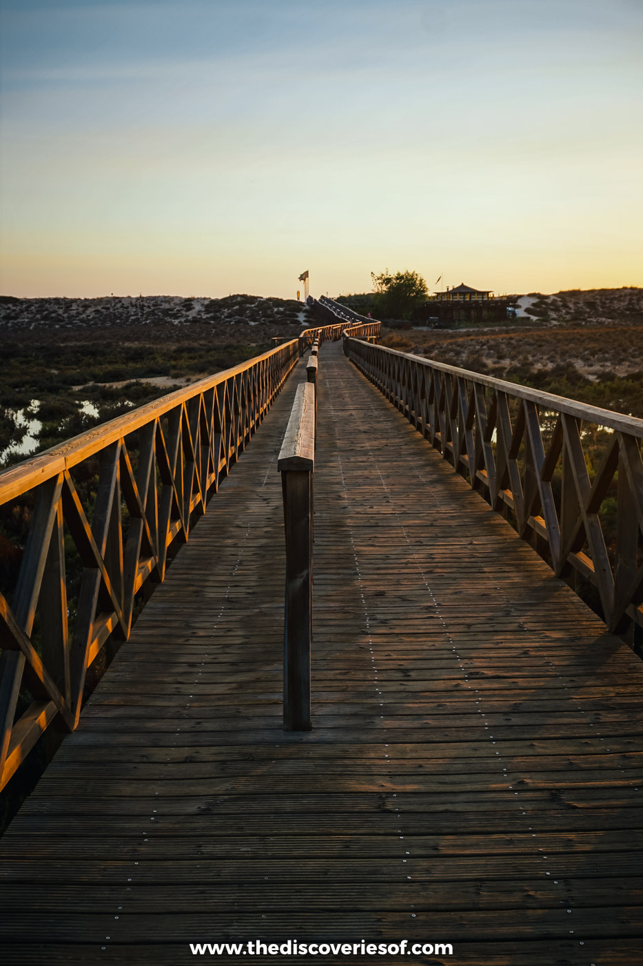 The long wooden footbridge across the Ria Formosa lagoon at Quinta do Lago in soft evening light