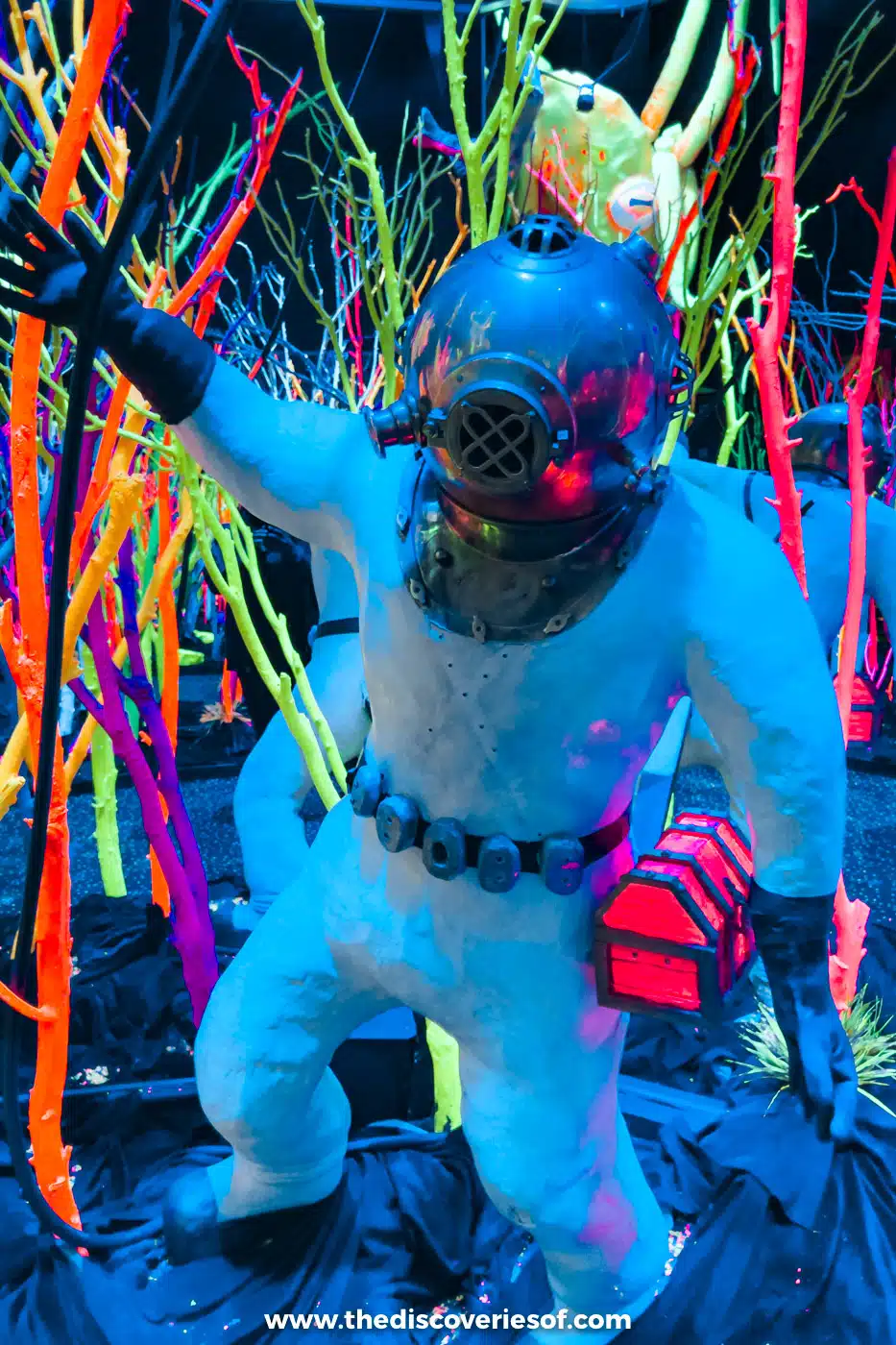 Figure of a deep-sea diver among neon-coloured branches inside Meow Wolf's House of Eternal Return in Santa Fe