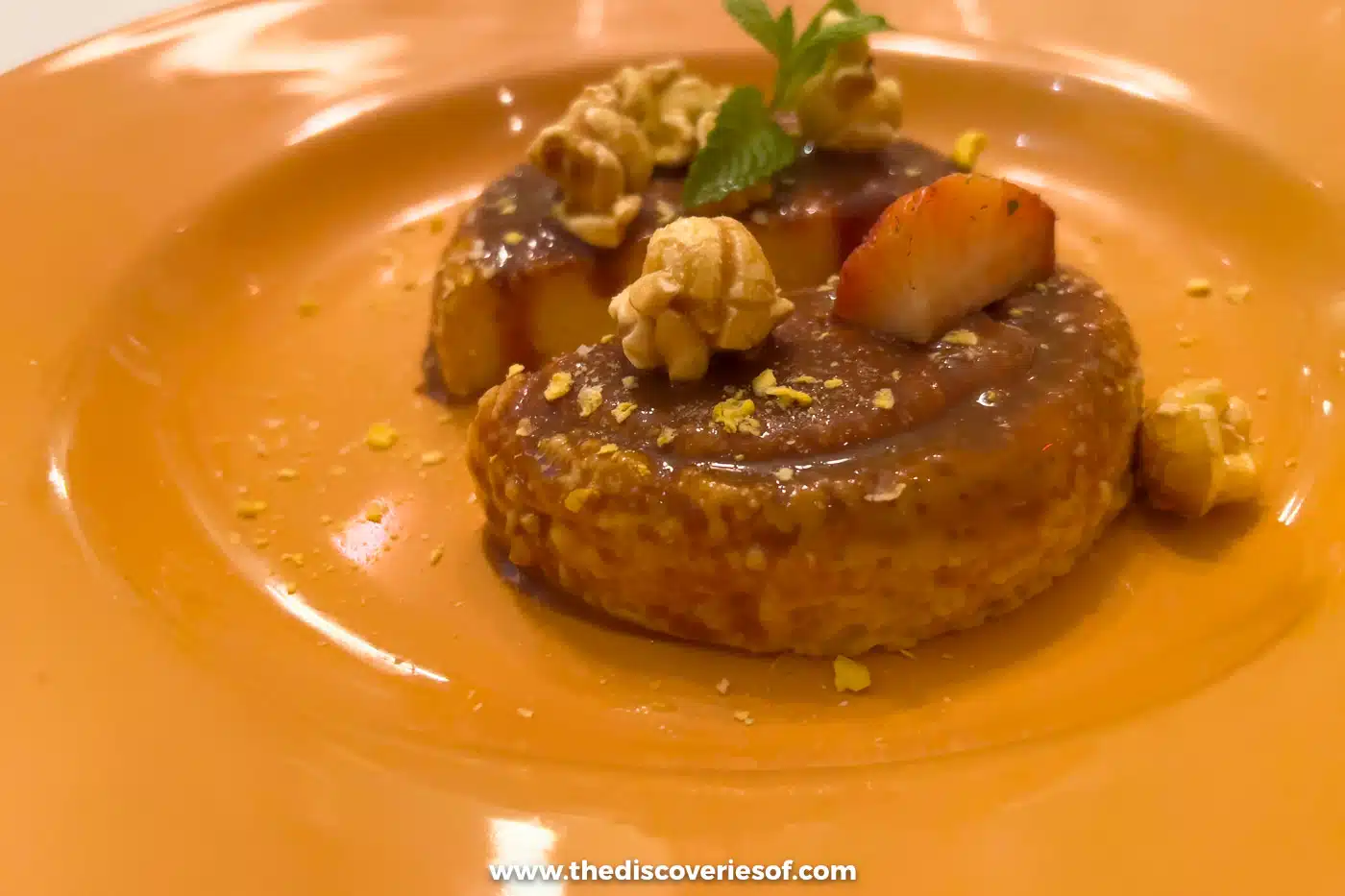 A plated dessert with caramel, popcorn and fresh strawberry on an orange plate at Zacatlán restaurant, Santa Fe
