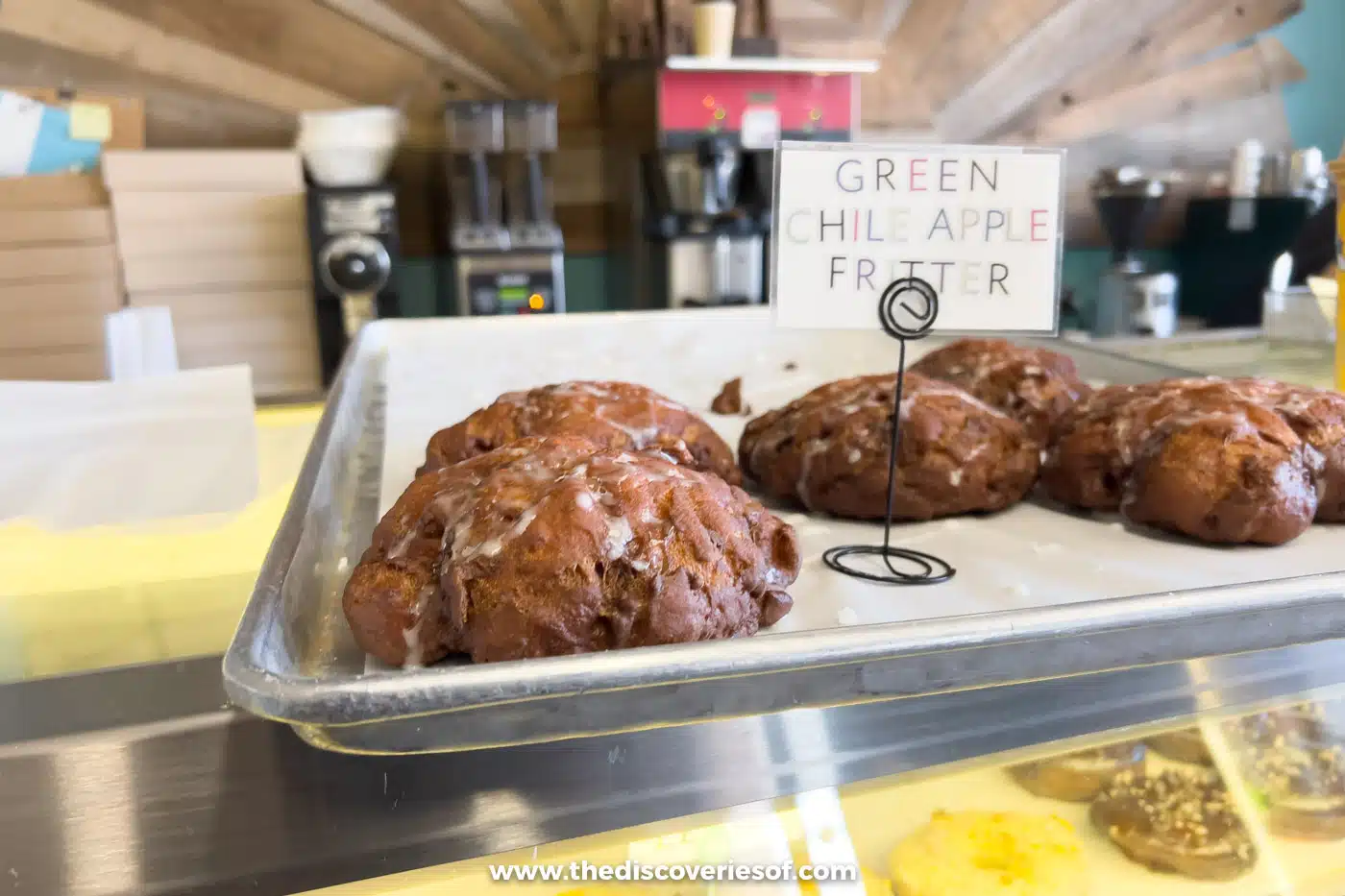 A tray of glazed green chile apple fritters behind the counter at Whoo's Donuts in Santa Fe