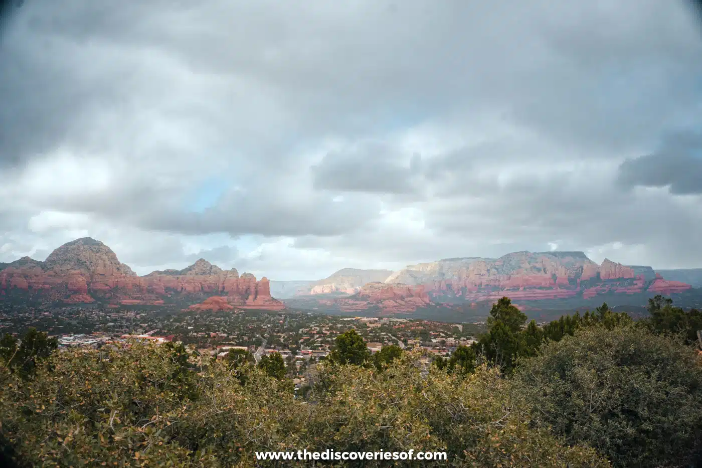 Wide view over Sedona and its red rock formations from Airport Mesa under cloud