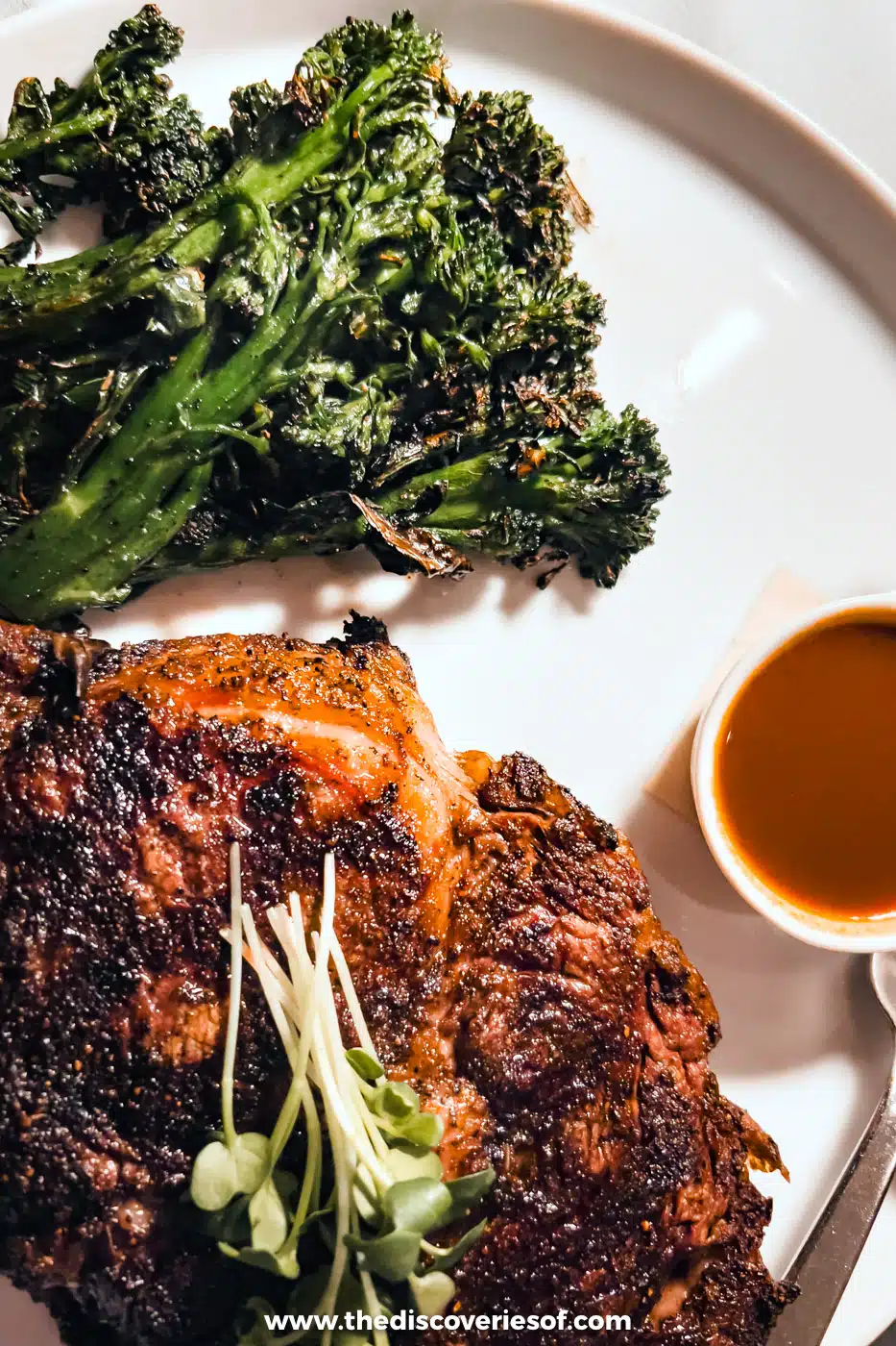 A chargrilled rib-eye steak with broccolini and a small pot of sauce at Radish & Rye in Santa Fe