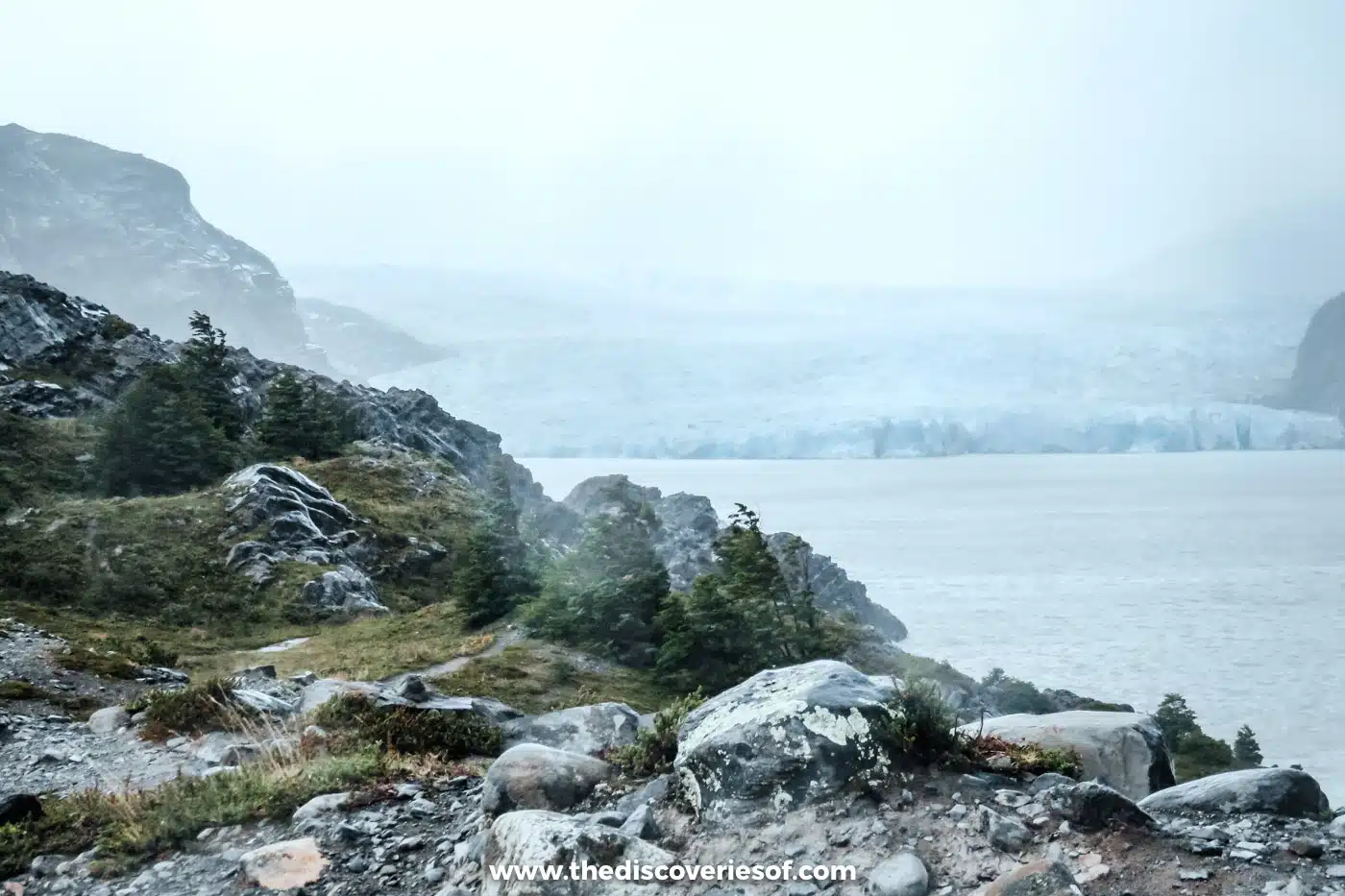 Glacier Grey in mist beyond rocks and forest, Torres del Paine, Chile