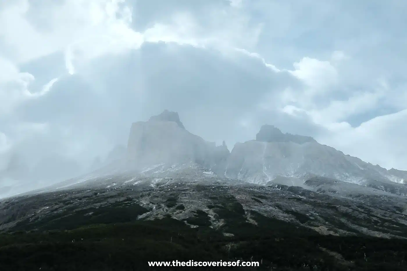 Mountain massif disappearing into cloud above the valley, Torres del Paine, Chile