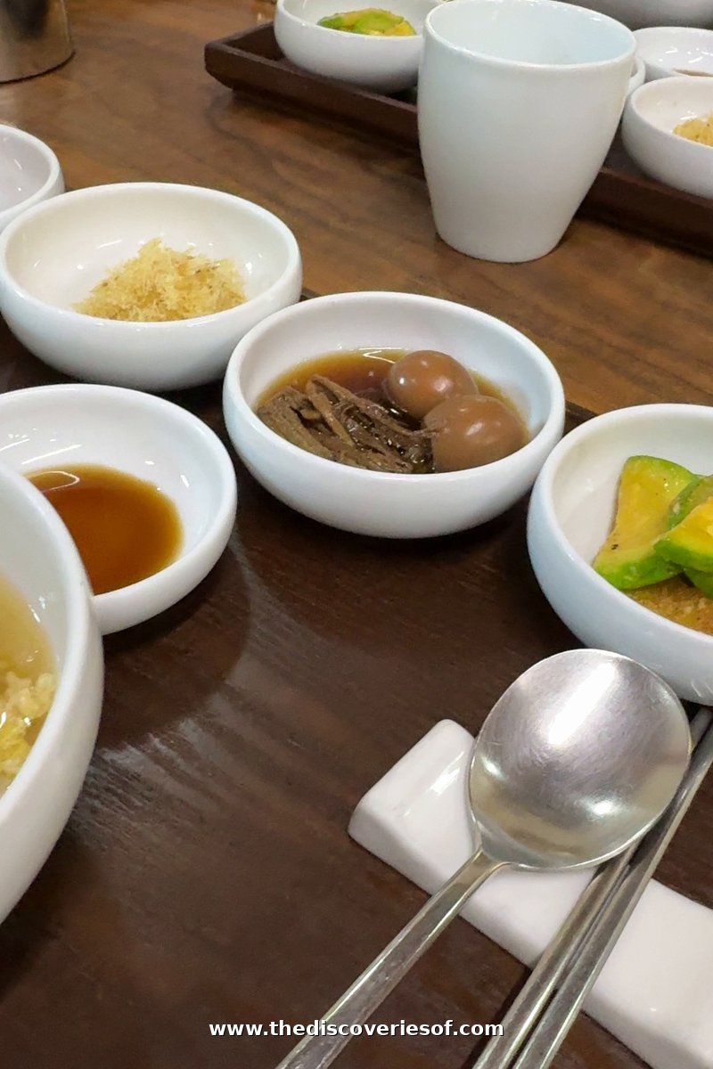 A traditional Korean breakfast of soup, banchan side dishes and dipping sauce on a wooden table at Tradition Resort Gurume, Andong