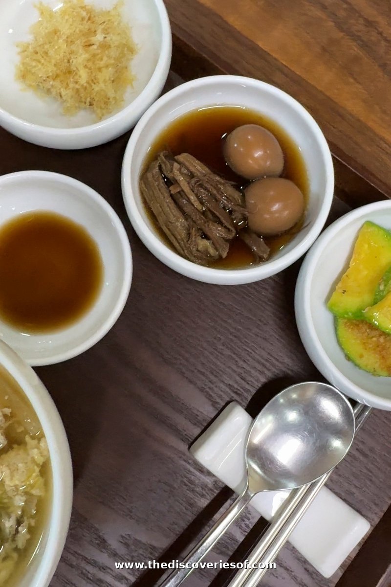 Soy-braised beef with quail eggs in a white bowl beside other side dishes at breakfast at Tradition Resort Gurume, Andong